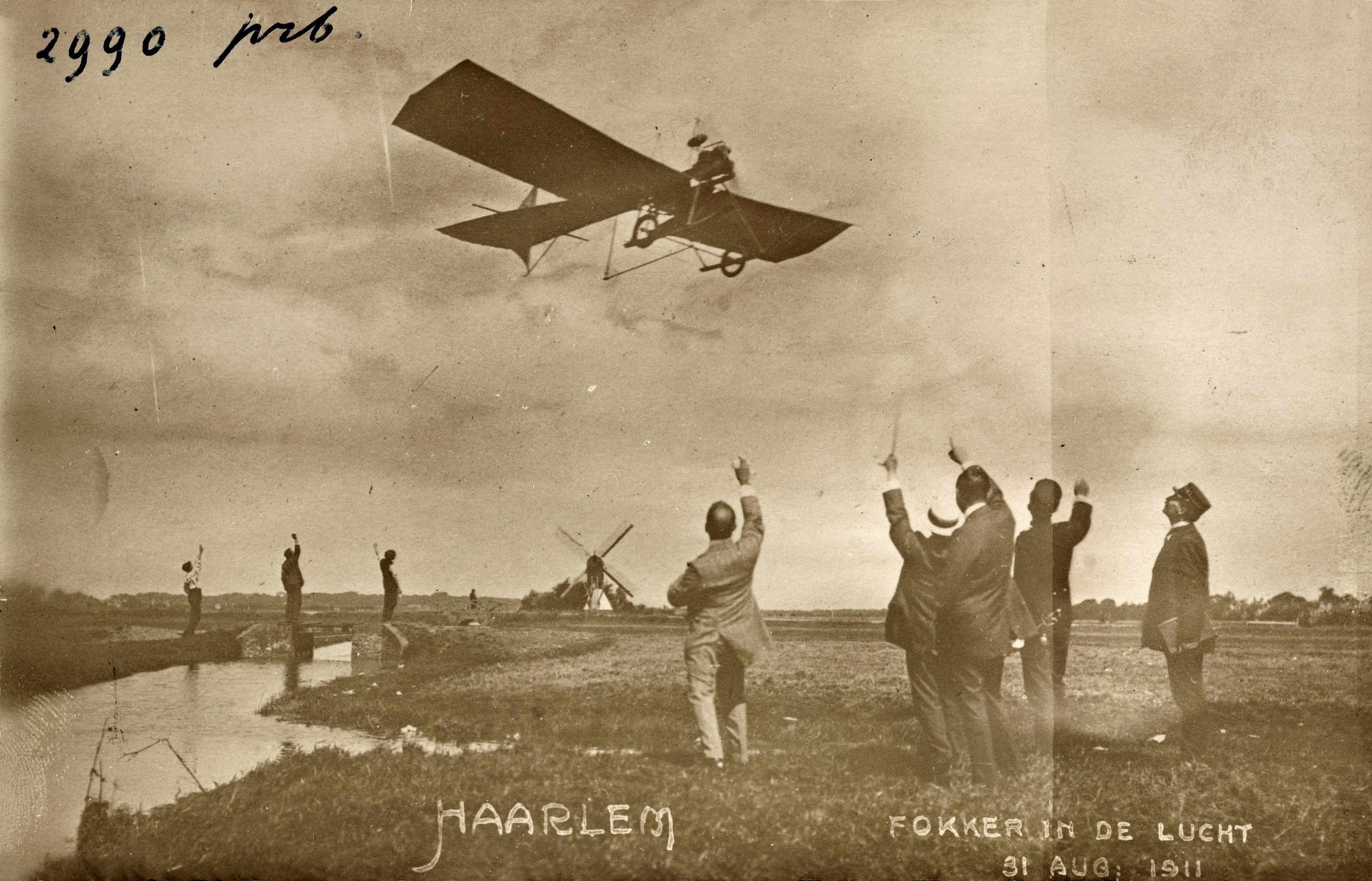 Foto uit 1911 van Fokker die met zijn Spin over de weilanden bij de Kleverlaan vliegt.