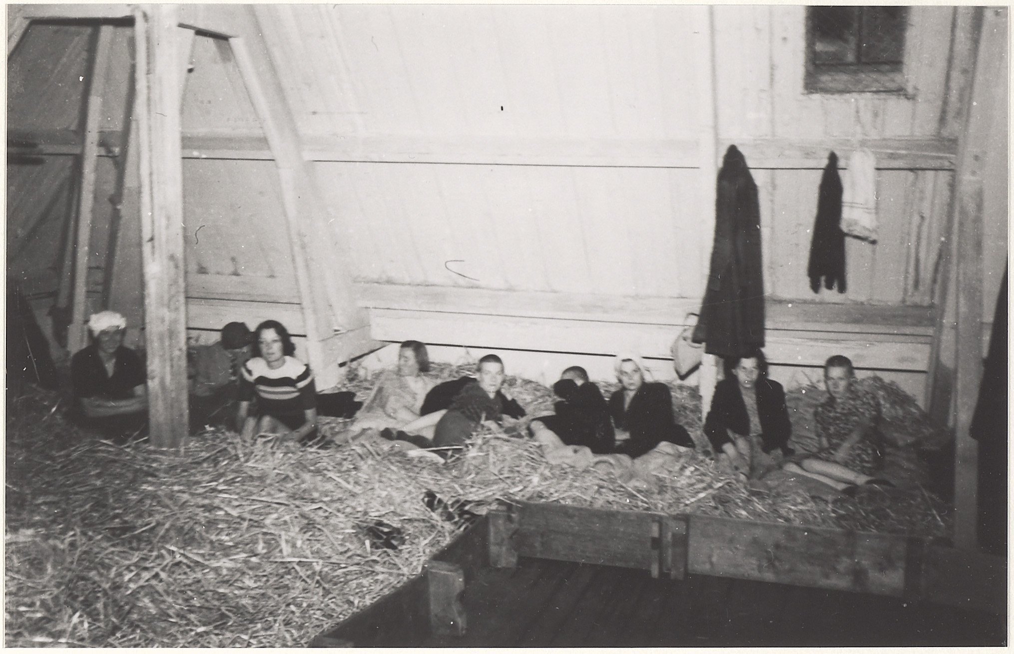 Op de foto zie je gearresteerde kaalgeschoren vrouwen van NSB'ers op stro matrassen op de zolder van de Infanterie kazerne aan de Koudenhorn. 